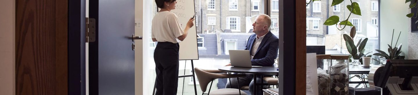 woman with a white board talking in a meeting - Careers page banner