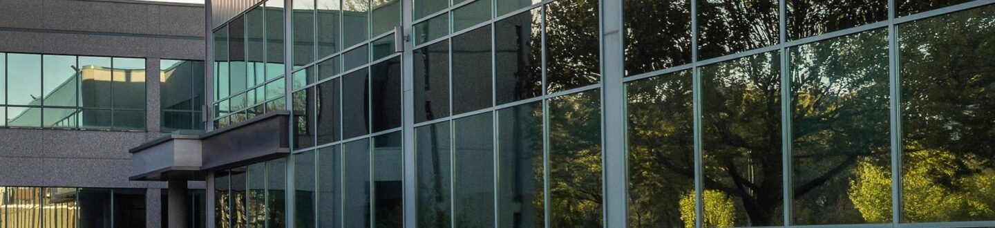 a building facade with glass windows - Mergers & Acquisitions and Transactions